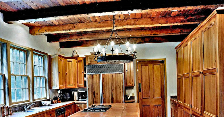 A. Hays Town kitchen design featuring heart pine beams, ceiling and cypress windows and cabinetry.