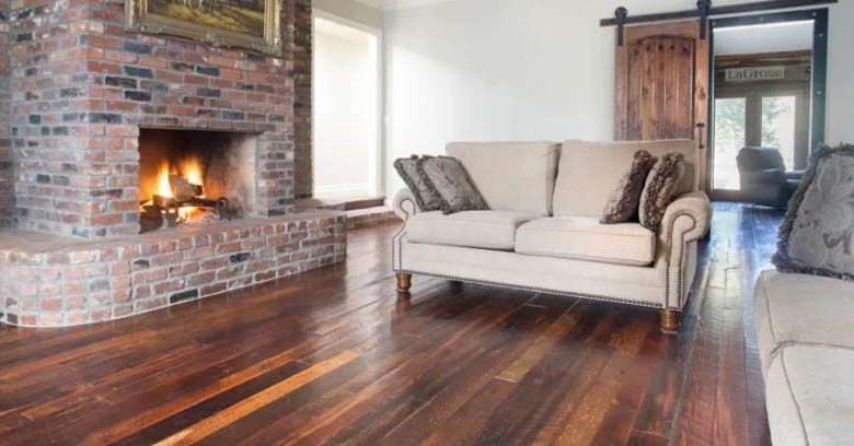 A cozy living room with roaring brick fireplace and Orleans Collection flooring from Albany Woodworks.