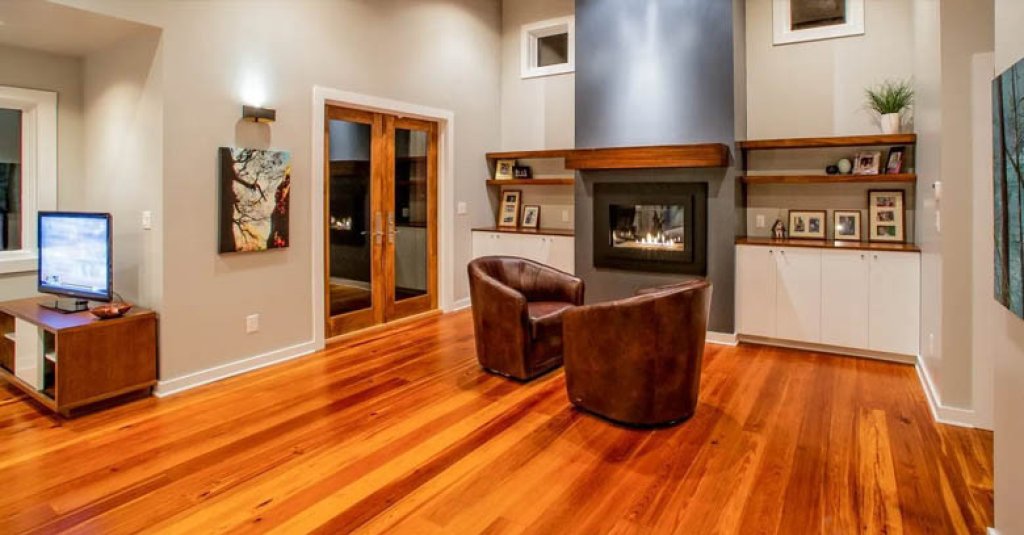 Antique heart pine flooring is a perfect compliment to solid wood shelving and above the mantel is a fireplace.