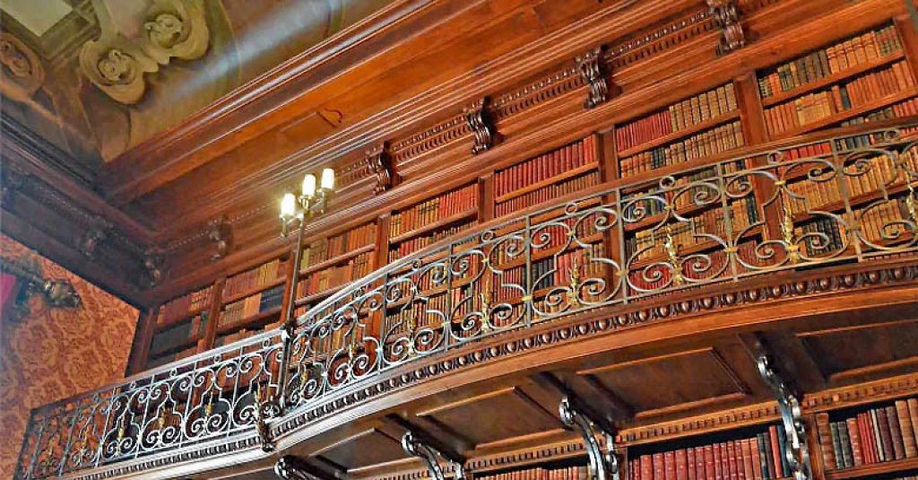 A two-story Library at The Biltmore Estate has intricate wood paneling.