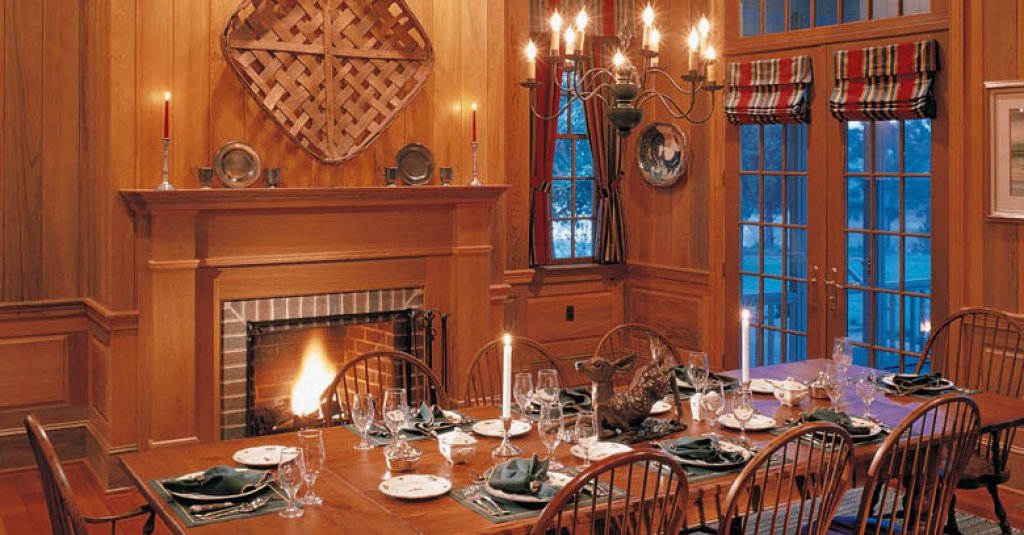 A warm fireplace in a dinning room made with custom cypress millwork from Albany Woodworks.