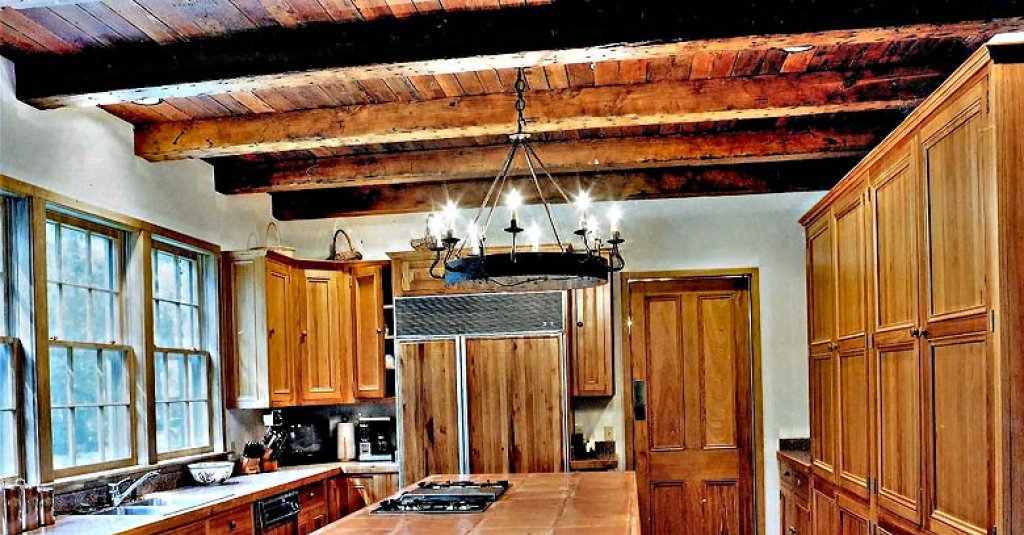 A. Hays Town kitchen design featuring heart pine beams, ceiling and cypress windows and cabinetry.