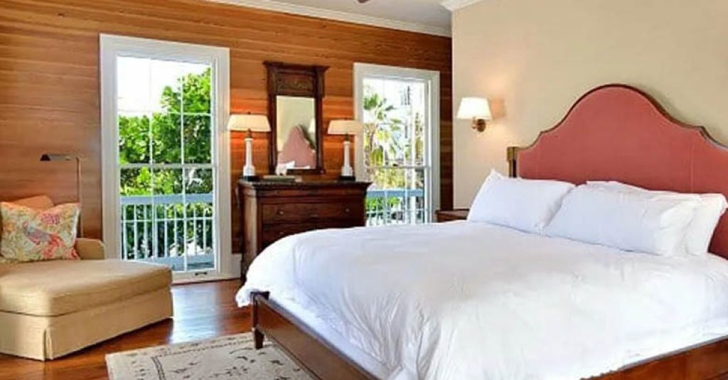 A cozy bedroom with rich Dade County Pine flooring and wall paneling.