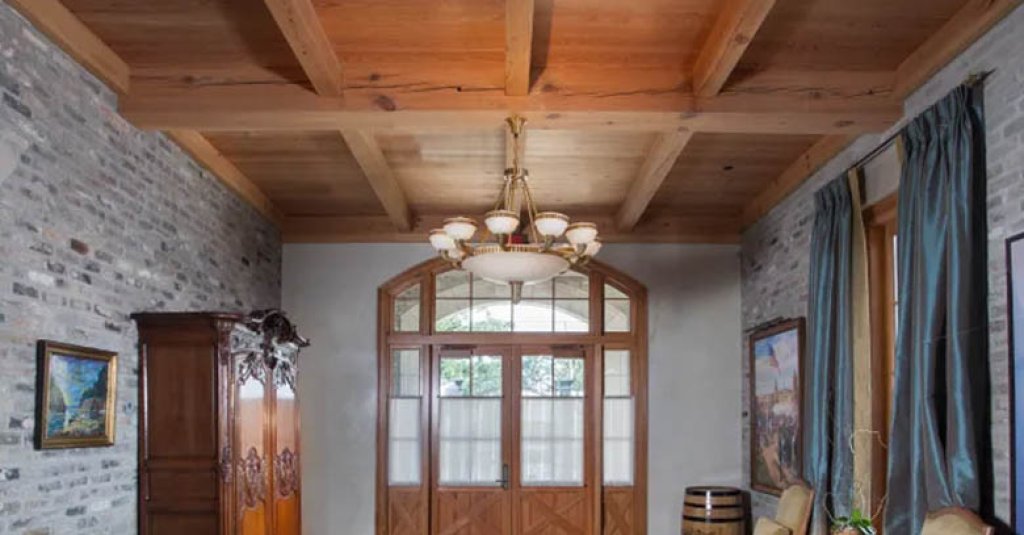 Antique heart pine beams in a entry way with a custom door.