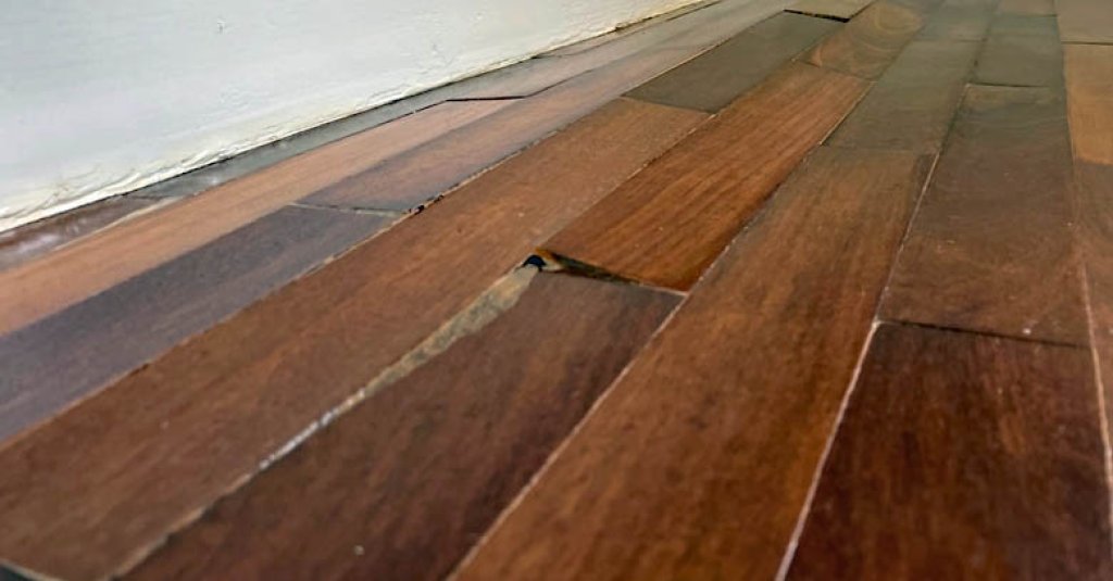 Buckled flooring damage caused by inferior wood or poor installation.